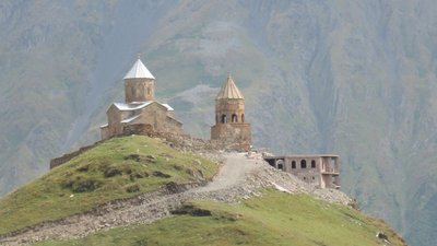 Georgische Heerstraße: Sameba-Kirche in Gergeti - im Hintergrund die Berge